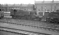 With the city of Nottingham's terraces forming the backdrop, Stanier 2-6-2T no 40165 stands alongside a converted tender in use as a sludge carrier at 16A's water softening plant. The photograph is thought to have been taken around 1961, the year the locomotive was withdrawn from nearby Kirkby in Ashfield shed.<br><br>[K A Gray //1961]