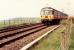311 098 approaching Ardmore Level Crossing going east.<br><br>[Ewan Crawford //1990]