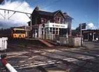 Class 303 about to cross over the level crossing at Balloch Central.<br><br>[Ewan Crawford //]