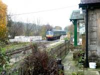A westbound train on the Wensleydale Railway about to pass over Wensley station level crossing on its way to Redmire in October 2004. [See image 32272]<br><br>[John Furnevel 30/10/2004]