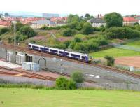A Glasgow Queen Street - Dunblane service runs past the washing plant at the north end of the new ScotRail depot at Eastfield on 27 August 2006. Note the fenced off embankment beyond the train, from which an 8-span plate girder viaduct once carried the Caledonian freight line actoss the E&G. [See image 9082]<br><br>[John Furnevel 27/08/2006]