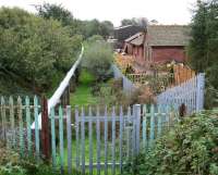 Looking south from the B721 road over the former station at Annan Shawhill on 12 October 2006 along the route that ran to the Solway Viaduct. The pipeline now occupying the trackbed carries waste (?) water from Chapelcross nuclear power station to the Solway Firth. [See image 19418]<br><br>[John Furnevel 12/10/2006]