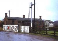 The old abandoned station at Scruton, between Northallerton and Leeming Bar, in 1982. View south over the level crossing.<br><br>[John McIntyre //1982]