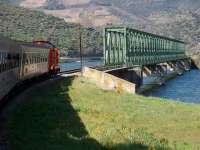 The English Electric exhaust of CP 1455 makes its familiar whistle as it leaves Ferradosa station and moves towards the river bridge, which is the only point between Pocinho and Oporto on the 110 mile Douro Valley line where the railway actually crosses the River Douro. <br><br>[Mark Bartlett 20/03/2008]