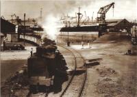 Caledonian Dock Shunter 56329 at King George V Dock with a train load of coal. The crane in the background belongs to the Barclay Curle shipyard in Whiteinch. The photo dates from the 1950s and is part of RailPhotoPrint postcard series. <br><br>[Graham Morgan Collection //]