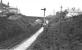 A view looking towards Bury at Brandlesholme Road Halt. The distant signal will be for the home signal protecting Tottington junction and the East Lancashire main line north of Bury Bolton St. [See image 21238] for a view of a train climbing through the cutting under the bridge. Side contact electric 3rd rail still in place. Print credited to N R Knight<br><br>[W A Camwell Collection (Courtesy Mark Bartlett) 05/02/1952]