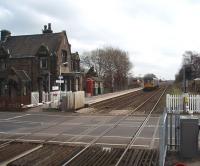 The original L&YR station building, now a private residence, still stands on New Lane's Up Platform. In front is a small waiting shelter and a traditional telephone kiosk. A Northern 142 Pacer, on a Southport to Wigan and Manchester service, hurries towards Burscough Bridge in this view across the level crossing from the staggered Down platform. <br><br>[Mark Bartlett 17/03/2009]