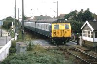 Frinton on Sea finally ceased to be a gated community in April 2009 when the level crossing on the only road access was converted to automatic barriers. This view of the crossing, taken on the evening of Sunday August 23rd 1981, shows a summer EMU service from Walton on Naze returning day trippers back up the line to Colchester.<br><br>[Mark Dufton 23/08/1981]
