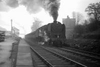 BR Standard class 9F 2-10-0 no 92097, having taken on WD 2-8-0 no 90434 as banker at South Pelaw, climbs through Beamish on an overcast Saturday 15 February 1964 with iron ore destined for Consett. By the time the train reaches its destination, it will have lifted its load from the import terminal at Tyne Dock bottom, on the south bank of the river, to the steel town, on the eastern edge of the Pennines, one thousand feet above sea level and, along the way, will have overcome gradients of up to 1 in 35. <br>
<br><br>[Robin Barbour Collection (Courtesy Bruce McCartney) 15/02/1964]