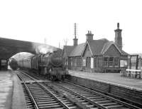 View west at Wennington in the early 1960s with Carnforth Black 5 no 44709 approaching with a train. At that time the lines to Lancaster and Carnforth split at a junction just beyond the bridge. <br>
<br><br>[Robin Barbour Collection (Courtesy Bruce McCartney) //]