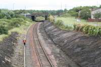 Looking east at the site of Bangour Junction in August 2007. The overbridge which now carries the A899 over the railway is the location of a signalbox associated with the branch which diverged in a north westerly direction immediately to the east of the overbridge, before it looped back on itself then once again reversed at the village of Dechmont before following a westerly route to it's terminus. A short lived private line, it existed to serve the hospital of the same name. The scrubland to the left contained a set of sidings associated with the branch, and a sizeable headshunt existed extending almost to the overbridge at Nettlehill. Most of the remains of the Bangour branch were obliterated with the A899 and M8 construction in this area.<br><br>[James Young 01/08/2007]