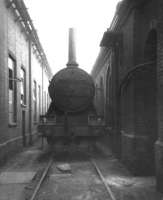 Gresley K3 2-6-0 no 61835 stands between two buildings at Peterborough's New England shed on 7 July 1963 having been rigged as a stationary boiler. The locomotive was officially withdrawn from here on 16 September 1963 and cut up at Doncaster Works the same month.<br>
<br><br>[David Pesterfield 07/07/1963]
