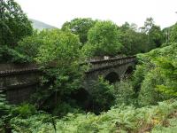 This concrete viaduct is about half way between Lochearnhead and St Fillans. Not easy to photograph because of trees it spans quite a deep gully. View looking west.<br><br>[John Gray 30/07/2009]