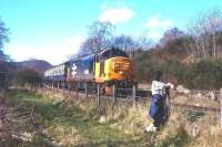 A reluctant trainspotter watches a Kyle-Inverness train drift east down the bank through Achterneed (closed 1965) heading for Dingwall in 1988.<br><br>[David Spaven //1988]