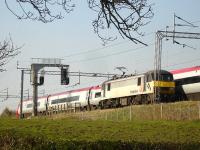 Freightliner 90047 being passed by a Pendolino on 22 April whilst approaching a stop signal south of Winsford Station. <br><br>[David Pesterfield 22/04/2010]