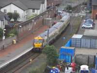 Ardrossan Town station, photographed from the Castle Hill on 14 June 2010 with 334 039 about to leave on the short (but slow) hop to Ardrossan Harbour. Road traffic on Princes Street has already been stopped. This was once a more substantial station with two through lines and two bays and a street-fronting building to the right. Remains of the original structure were still obvious when the station reopened in 1987 as a single platform, but all has now gone.Happily though the platform is being extended at the eastern end (off camera).<br>
<br><br>[David Panton 14/06/2010]