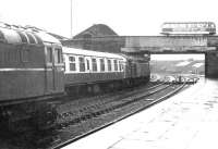 A downpour at Dumfries in 1972 as an EE Type 4 leaves the station with a train for the south passing 5378 standing on the centre road. The roof of the former Dumfries locomotive shed, closed approximately 7 years earlier, is visible just beyond St Mary's Street Bridge. <br><br>[John Furnevel 28/05/1972]