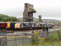The stored DRS lcomotives at Carnforth seem to be moved around the yard quite a bit - presumably to keep things from seizing up. 37261, 37612 and 37605 are seen here from the station platform, in front of four stored Class 20s, with the depot coaling tower and ash plant behind. Will there be any RHTT work for these locos this autumn? Postscript: Later that same day four more DRS Class 20s (20309/10/11/12) arrived from Carlisle for storage in the yard here.<br><br>[Mark Bartlett 14/09/2010]