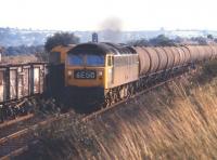 Class 47 no 1879 on a northbound train of oil tanks, thought to be returning empty to Tees-side, on the Midland 'Old Road' at Killamarsh in July 1971. The train is passing a pair of class 20s heading an unbraked train of 16t coal wagons south on the up line.<br><br>[Bill Jamieson 21/07/1971]