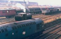 D5302 passes Niddrie West Yard, Edinburgh, watched by the crew of NCB Lothians Area no 25 (Barclay 2358 of 1954) in the exchange sidings for Niddrie Landsale Yard in 1971. Beyond are vehicles belonging to the civil engineer who had taken over the sidings by this time.<br><br>[Bill Roberton //1971]