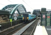 A Carlisle - Middlesbrough train crossing the River Wear after passing through the platforms of St Peters station, Monkwearmouth, in July 2004. The station was built as part of the Tyne & Wear Metro development. The former Monkwearmouth station, now a museum, stands 100m behind the camera [see image 17890].<br><br>[John Furnevel 10/07/2004]