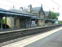 View south at Morpeth station on the ECML on a May afternoon in 2004. Visible just beyond the attractive station buildings on the up platform is the start of the infamous <I>Morpeth Curve</I>, the most severe curve (17 chains (340 m) radius) on any main line in Britain, turning through almost 90 degrees immediately south of the Station. The curve has been the scene of three major derailments over the years. There is a permanent speed restriction of 50mph through this section of the ECML.<br><br>[John Furnevel 28/05/2004]