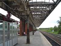 Looking east along platform 3 at Wakefield Kirkgate showing the original canopy, albeit devoid of glass, still in situ on 16 May 2011. At the far end of the former overall roof support wall the canopy also runs fully across platforms 2 & 3. Surveyors can be seen at the far end of the platform. They indicated that the platform was due to be cleared fully to leave just a waiting shelter. Platform 3 is used by the local Pontefract line service plus the three return Grand Central services between Bradford Interchange and London Kings Cross; including the 11.13 service which I was waiting to join. For the same scene 34 years earlier [see image 39219]<br><br>[David Pesterfield 16/05/2011]