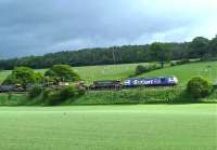 A <I>Stobart Rail</I> liveried class 92 locomotive hauling a southbound ballast train on the west coast main line on 24 May 2011. The location is approximately 6 miles north of Lockerbie near the site of the former Dinwoodie station (closed 1960).<br>
<br><br>[Bruce McCartney 24/05/2011]