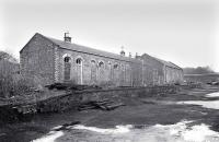 The derelict station building at Penicuik with the goods shed beyond, seen here in December 1976. Closed to passengers in September 1951 the last freight called here in April 1967 [see image 29992]. No trace of the station site remains, with the area shown in the photograph now occupied by a housing development.<br>
<br><br>[Bill Roberton /12/1976]