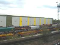 Passing shot showing a fairly crowded Wolverhampton steel terminal on 12 October, with various loads of plate, section and coil visible in the sidings. DBS 66238 stands in the right background, with hooded rail wagons beyond at the far end of the transit shed.  <br><br>[David Pesterfield 12/10/2011]