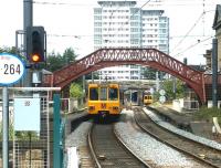 A Tyne and Wear Metro service bound for Newcastle heads north shortly after leaving St Peters station on the north bank of the River Wear in 2004. The train is running through the abandoned platforms of the 1848 Monkwearmouth station and is about to pass an approaching service heading for South Hylton.<br><br>[John Furnevel 10/07/2004]