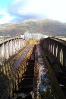 Looking across the old rail bridge over the River Devon on 12 November 2011. View north through a gap in the metal fence towards Menstrie, with the Ochil Hills beyond.<br><br>[Grant Robertson 12/11/2011]