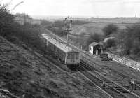 The 11.51 Leeds to Sheffield via Barnsley stopping train recedes from the camera and makes for its next stop at Wakefield Kirkgate in April 1976, having just passed Lockes Sidings signal box [see image 37445]. Notable features on the horizon are Emley Moor TV transmitter just to the left of the train and the spire of Wakefield Cathedral near the right hand edge of the picture.<br><br>[Bill Jamieson 03/04/1976]