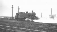 BR Standard class 2 2-6-2T no 84018 in the sidings at Wyre Dock junction, Fleetwood, on 29 June 1963. The photograph is taken from alongside the signal box with the now-demolished Fleetwood power station in the right background. Fleetwood shed (24F) from which the locomotive was withdrawn in April 1965, stands directly behind the camera. Official closure took place in February 1966.<br><br>[K A Gray 29/06/1963]