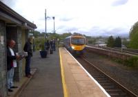The 12.28 to 'Oxenholme and all connections everywhere' coasts into Kendal under a glowering sky, with the mountains of the Lake District in the background. [see image 25577 for a view looking the other way]<br><br>[Ken Strachan 13/05/2012]