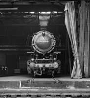 From the looks of the curtains the Putzfrau (cleaning lady) at Wanne-Eickel depot in the Ruhr has been neglecting her duties! A 3 cylinder 2-10-0 contributes to the murk as it whiles away a Saturday afternoon in August 1975 on one of the stabling roads inside the shed, which was accessed via a traverser.<br><br>[Bill Jamieson 30/08/1975]