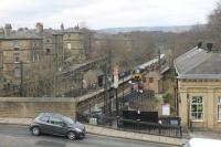 Saltaire station, seen from nearby Salt's Mill, as 333014 leaves for Keighley and Skipton. The station was closed from 1965 to 1984 but is now very busy and sees four trains per hour in each direction. Some of the houses at this world heritage site can be seen to the left of the station.<br><br>[Mark Bartlett 19/04/2013]