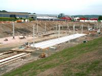 The Edinburgh Gateway tram stop under construction on 10 June 2013. View is east with Gogar roundabout and the Edinburgh tram depot behind the camera. On the upper level In the background the 11.21 Glenrothes with Thornton - Newcraighall service is passing through the site of the new station.<br><br>[John Furnevel 10/06/2013]