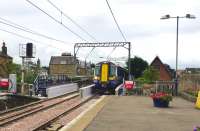 The 10.23 Ayr - Glasgow Central rolls into Prestwick station on 3 July over the newly installed replacement underbridge at the south end of the station.<br><br>[Colin Miller 03/07/2013]