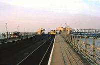 Cars on New Holland Pier in 1975 queueing for the ferry, while a DMU for Cleethorpes waits in the background to connect with the next arrival from Hull. [See image 42310]<br><br>[Ian Dinmore //1975]