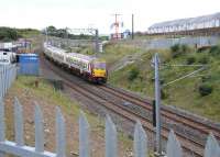 The 14.11 Helensburgh Central - Edinburgh Waverley slows for the Armadale stop on 23 September 2013, passing another new housing development. <br><br>[John Furnevel 23/09/2013]
