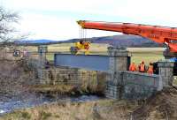 The first girder is slowly eased into position at Dulnain Bridge on the Strathspey Railway on 14 February 2014.<br><br>[John Gray 14/02/2014]