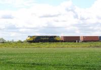 An eastbound container train on the Great Western main line passing the village of Bourton on the outskirts of Swindon on 13 May 2014. The locomotive is Freightliner 70009. <br><br>[Peter Todd 13/05/2014]