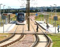<I>'Oh ...ballast!!!'</I> Three fed up looking would-be passengers just miss a Sunday morning city bound Edinburgh tram leaving Ingliston Park and Ride on 13 July.<br><br>[John Furnevel 13/07/2014]