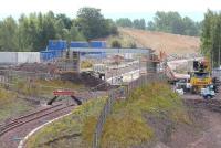 A new bridge being built over the Borders Railway route just beyond the turnback siding at Millerhill. The bridge will carry the road serving the recycling plant to be constructed on former railway land to the west of the current yard, with access from Whitehill Road. View south west towards Shawfair on 5 August 2014.<br><br>[John Furnevel 05/08/2014]