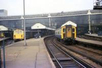 Looking back along the platform towards the buffers at London Waterloo station in March 1976 as 4-TC set no 433 departs past a class 74 electro-diesel with a parcels train. In the shadows on the left a class 08 and a class 33 can also be made out.<br><br>[John McIntyre 19/03/1976]
