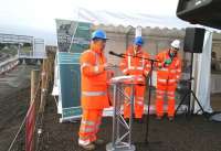 Part of the formal proceedings at the Borders Railway tracklaying event at Shawfair on 9 October 2014. Left to right are Scotland's Transport Minister Keith Brown, Network Rail CEO Mark Carne and Borders Railway Project Director Hugh Wark. Another key contributor on this damp and chilly morning is the gentleman on the far right just inside the marquee, busy preparing coffee and the best bacon rolls ever...<br><br>[John Furnevel 09/10/2014]