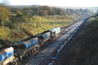 A low autumn sun casts shadows over the cutting at Tynehead on 10 November 2014, as Freightliner 66610 idles on the south end of a Borders Railway ballast train.<br><br>[Ewan Crawford 10/11/2014]