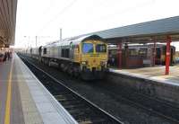 Freightliner 66506 heads north through Wigan North Western on 2 December 2014 with a rake of coal empties from Fiddlers Ferry. Over on Platform 5 a Northern Sprinter waits to return to Liverpool Lime St via St. Helens, a route that went over to EMU operation during 2015. <br><br>[Mark Bartlett 02/12/2014]