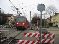 A service for Uetilberg [see image 49615] on the level crossing at Freisenberg in the Zurich suburbs in November 2014. Note the mish-mash of overhead wires - the road carries Zurich trolleybus route 32.<br><br>[Michael Gibb 30/11/2014]